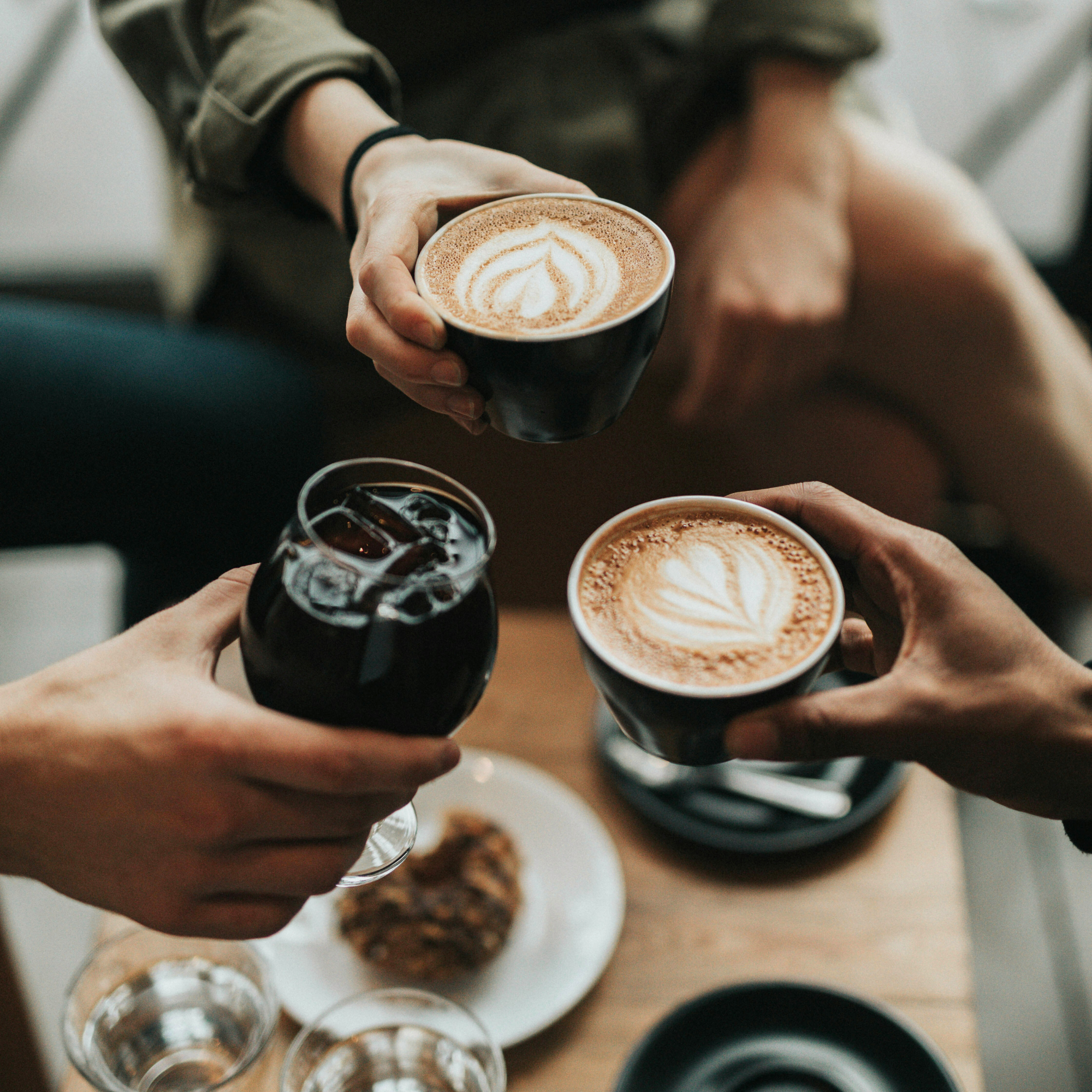 Coffee Shops - a beautifully crafted latte displayed in a white cup on a rustic wooden table.